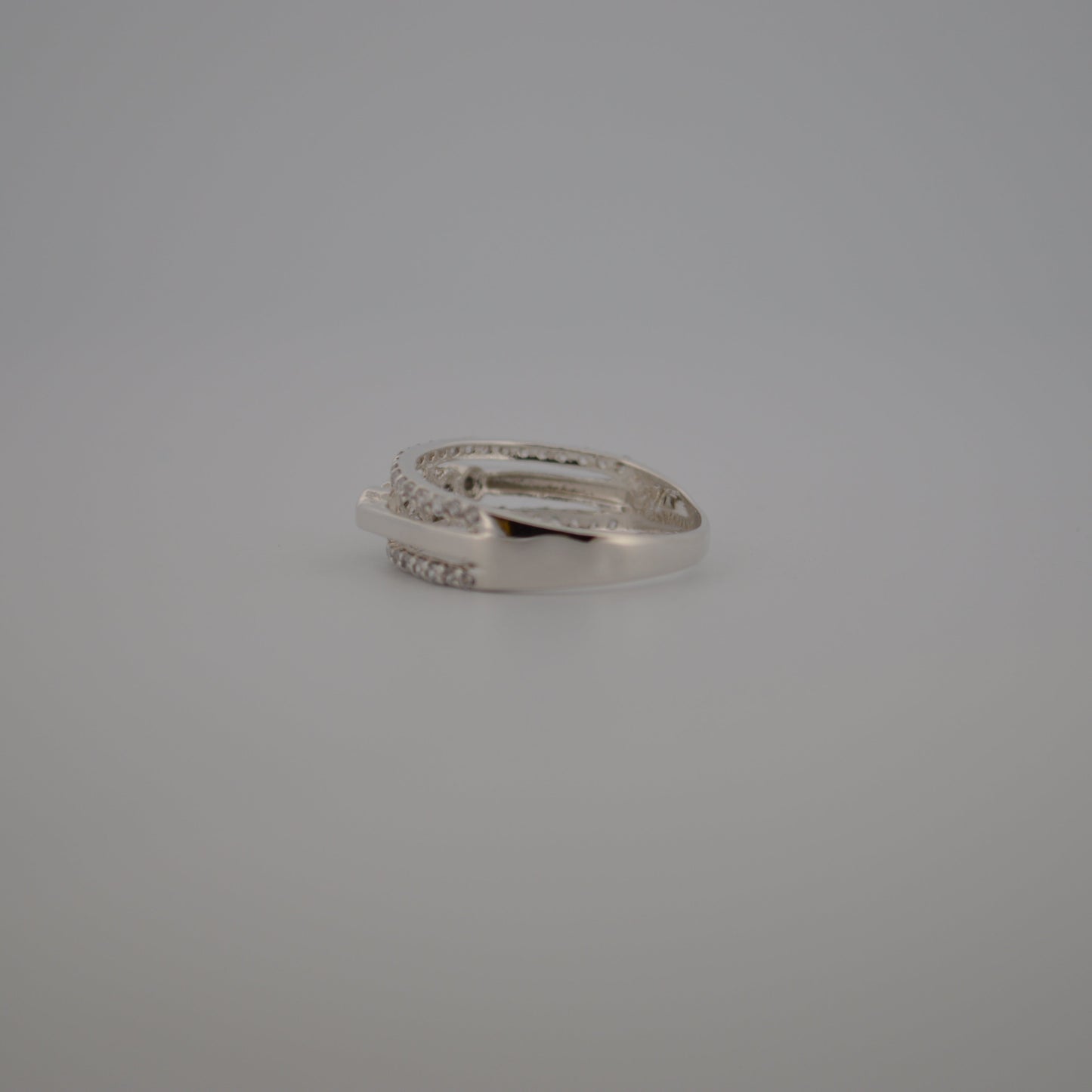 Silver ring with small diamonds on a gray background