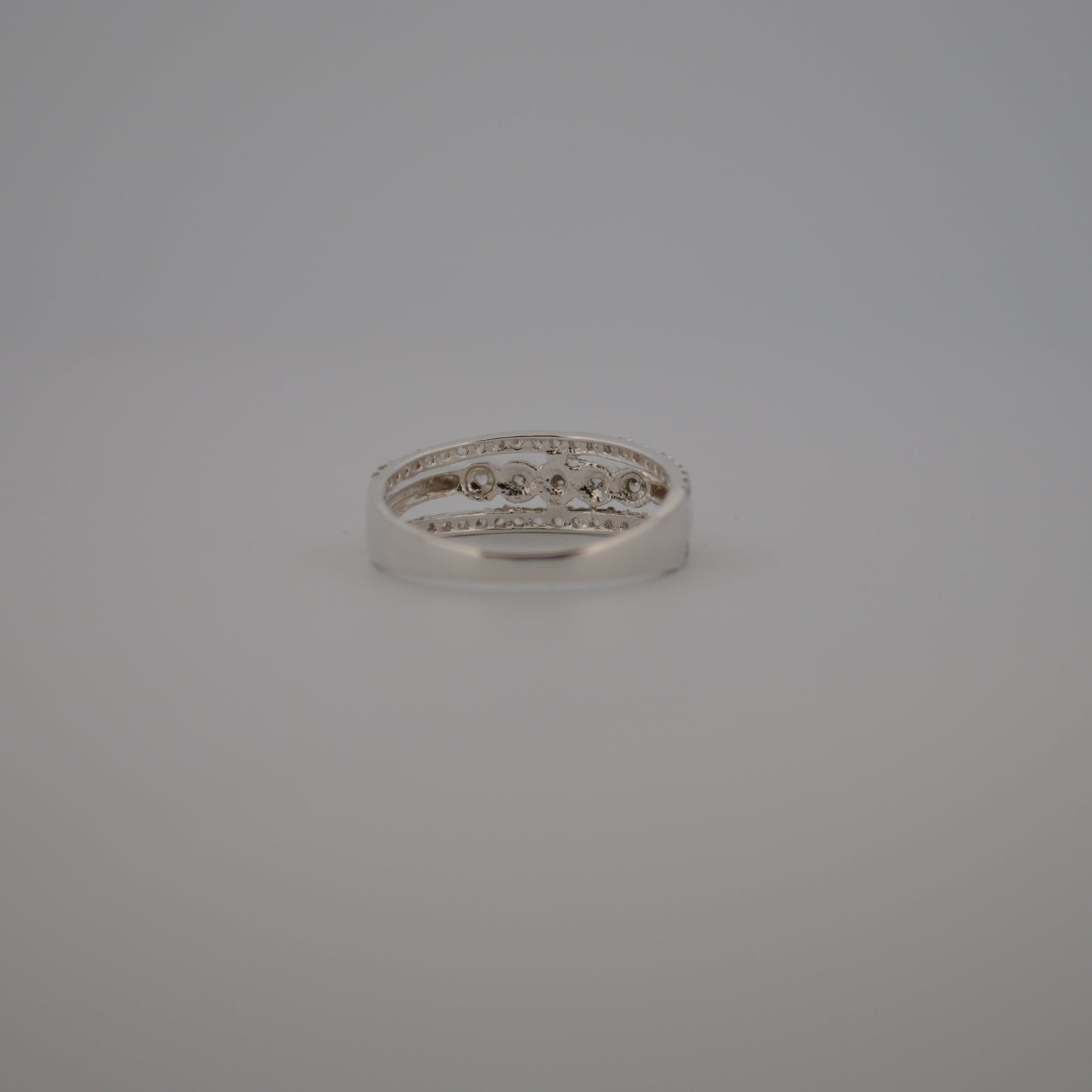 Silver ring with small diamonds on a gray background