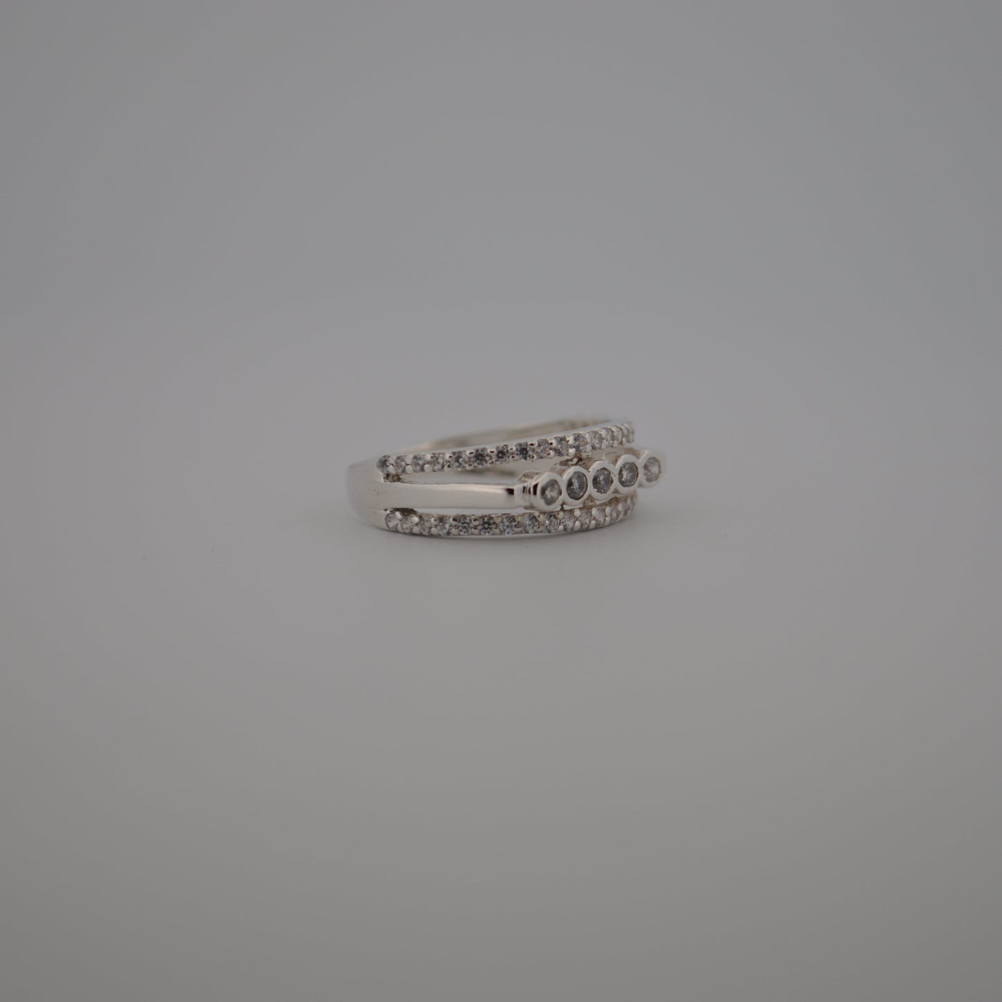 Silver ring with small stones on a gray background