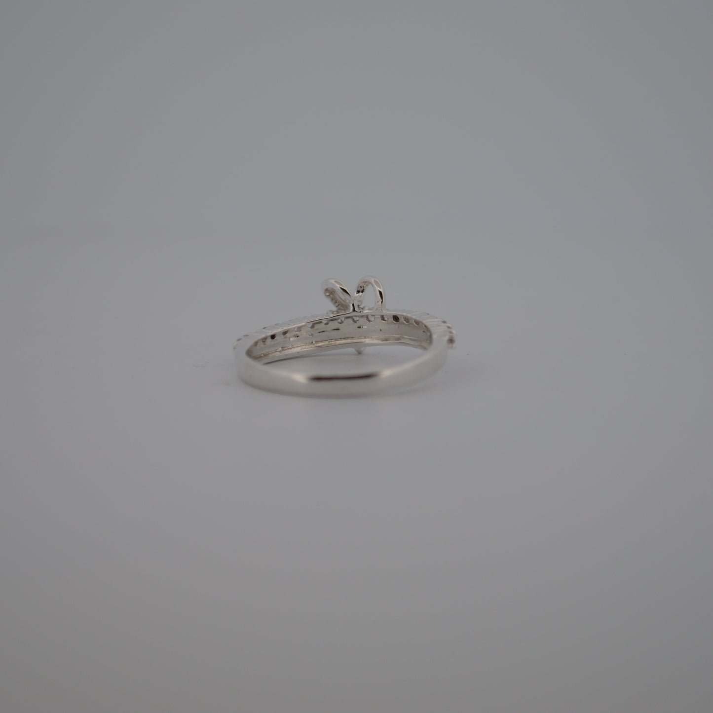 Silver ring with a diamond on a gray background