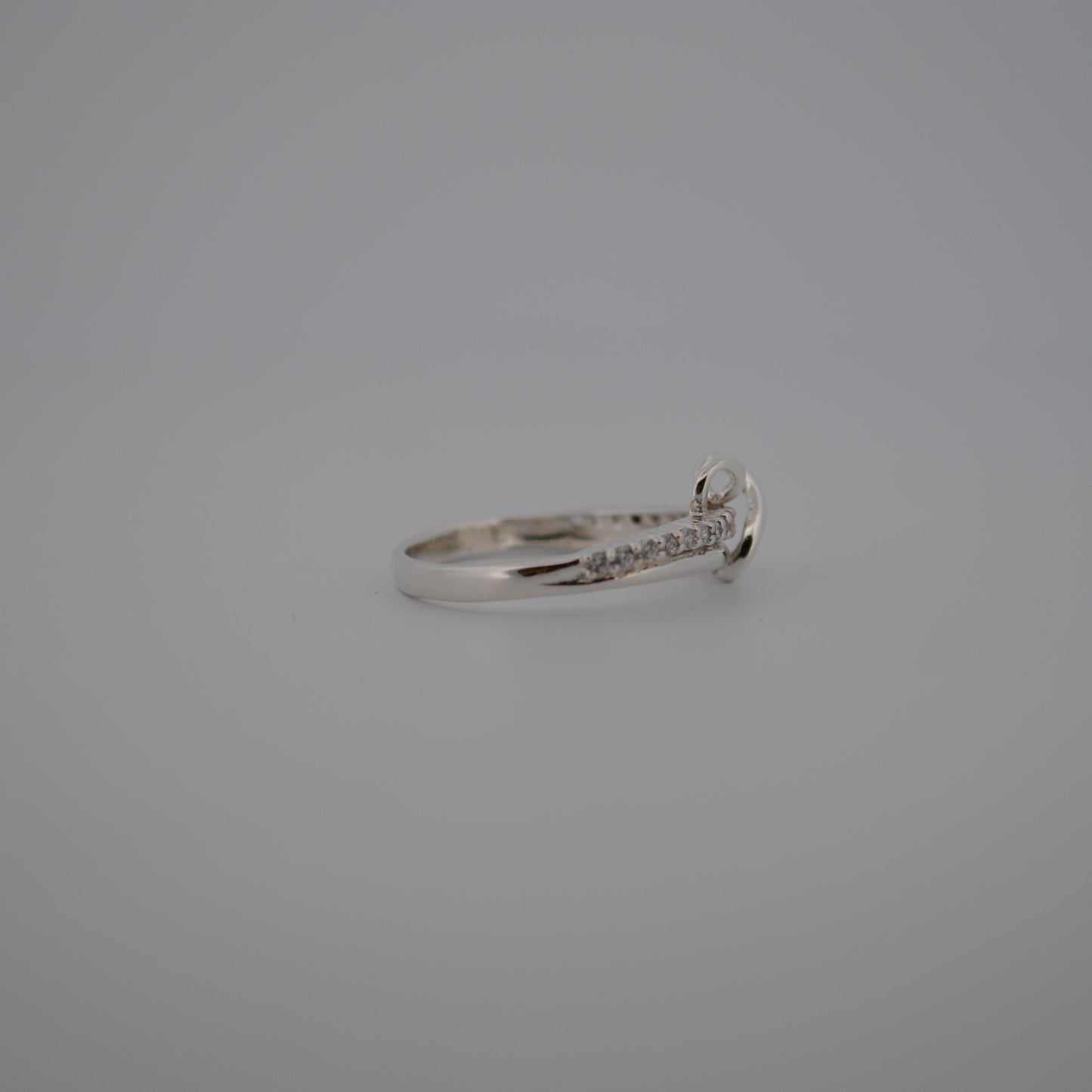 Silver ring with small diamonds on a gray background