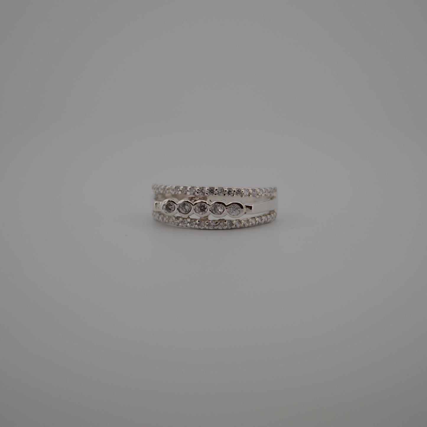 Silver ring with small stones on a gray background