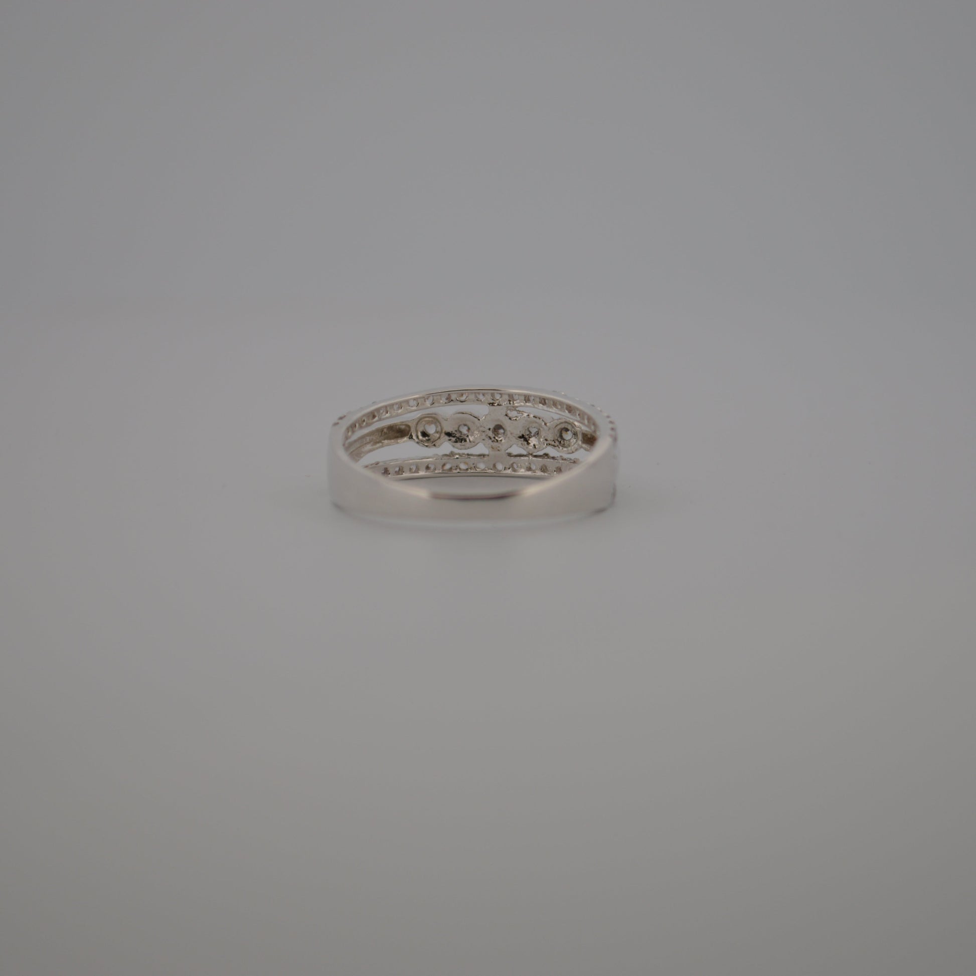 Silver ring with small diamonds on a gray background