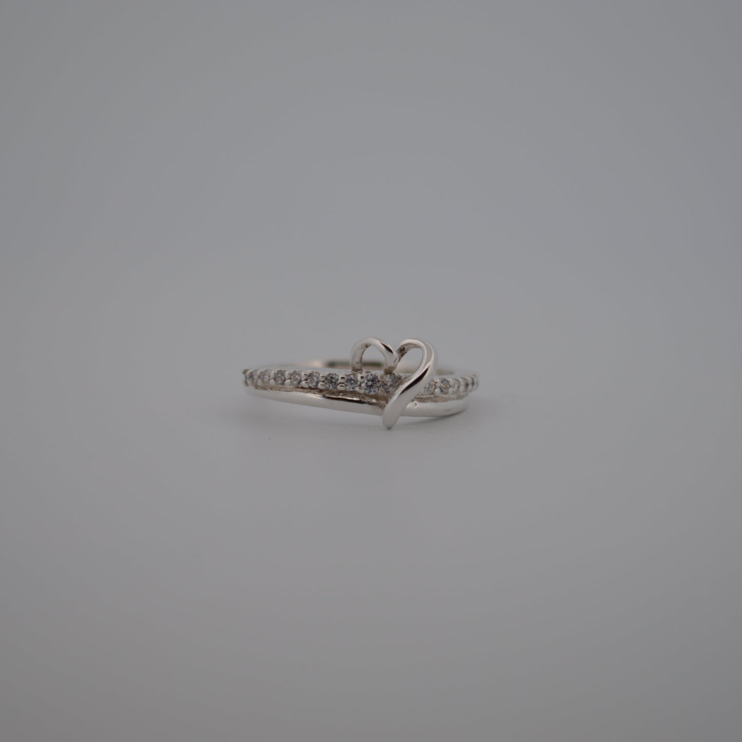 Silver ring with small diamonds on a gray background