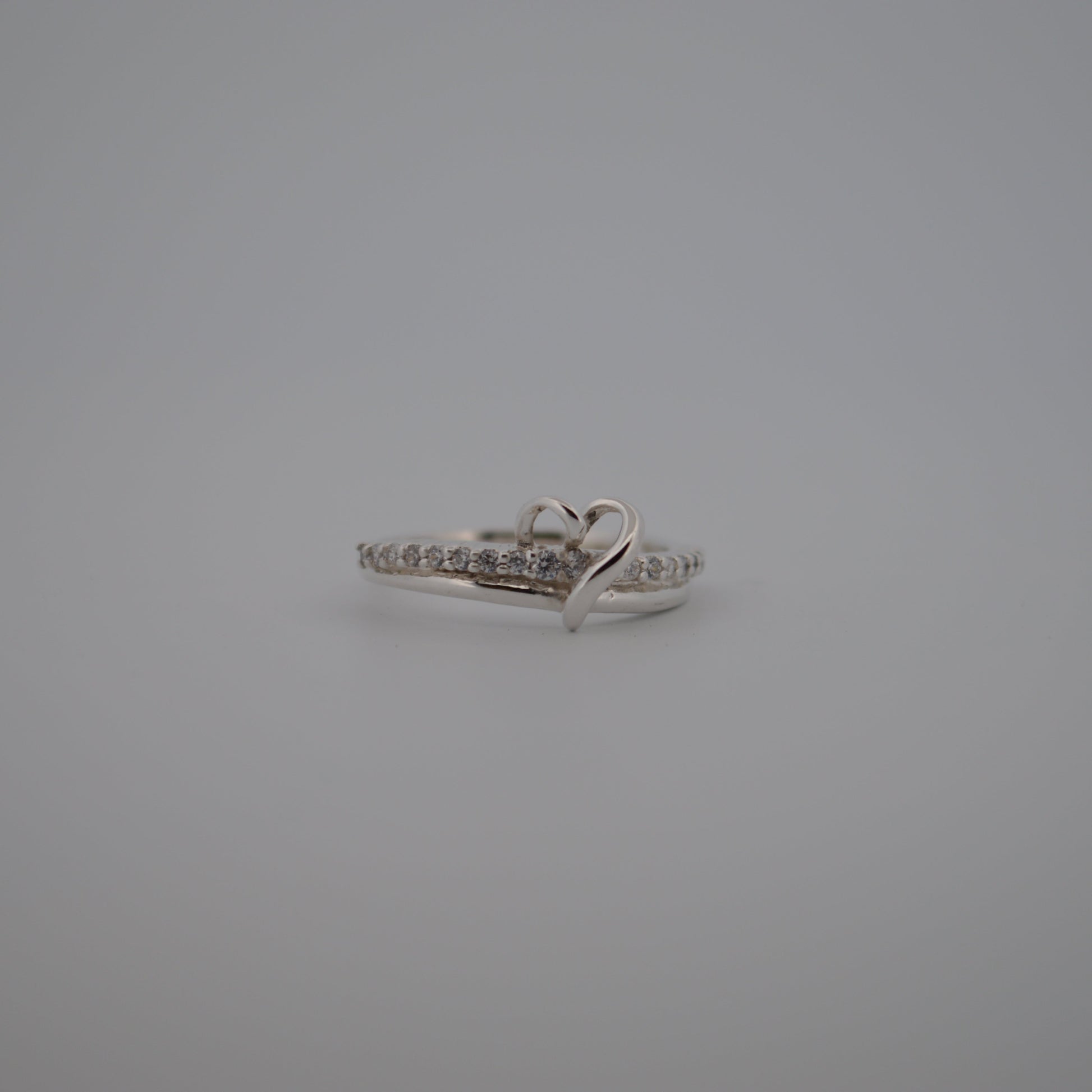 Silver ring with small diamonds on a gray background