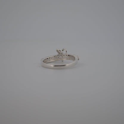 Silver ring with a diamond on a gray background
