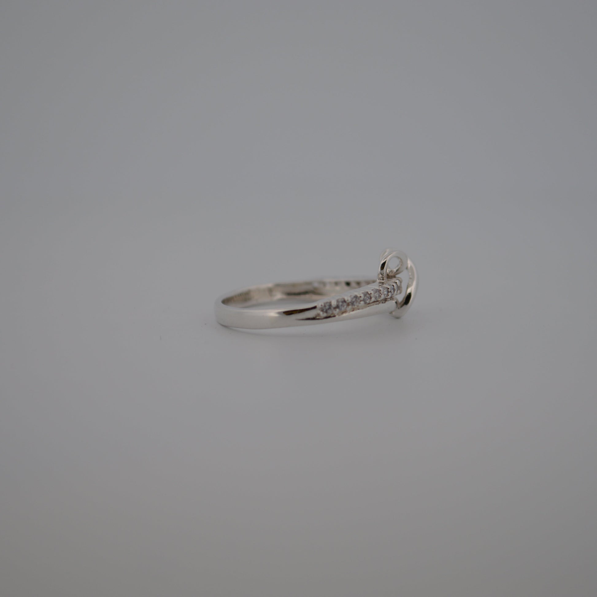 Silver ring with small diamonds on a gray background