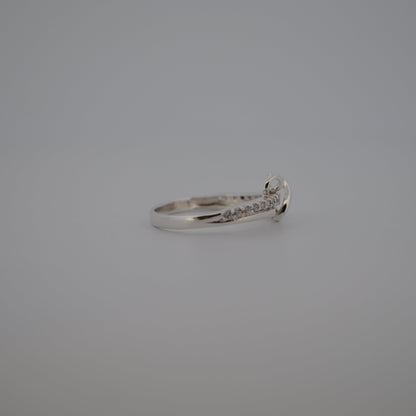 Silver ring with small diamonds on a gray background