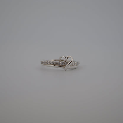 Silver ring with heart design on a gray background