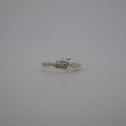 Silver ring with heart design on a gray background