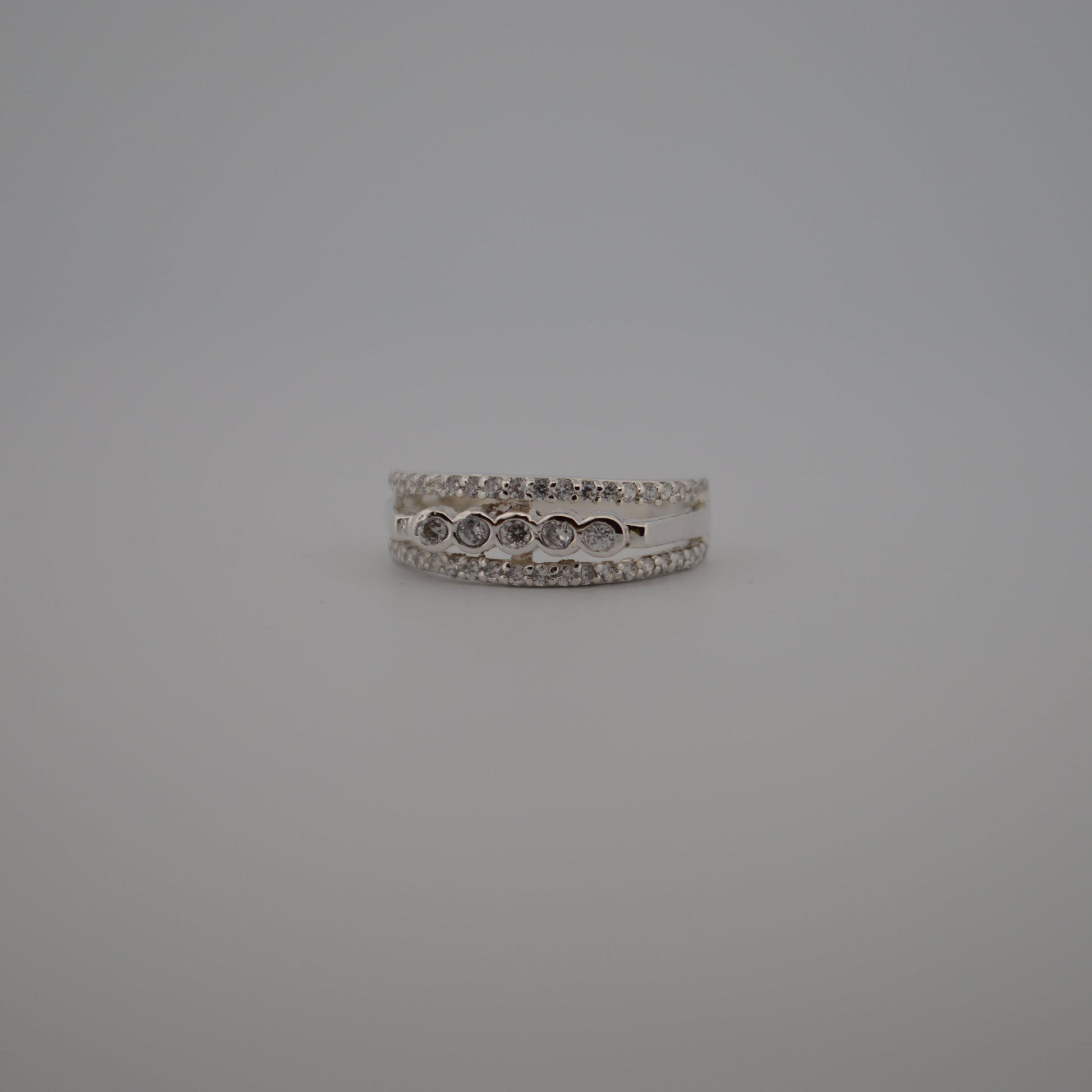 Silver ring with small stones on a gray background