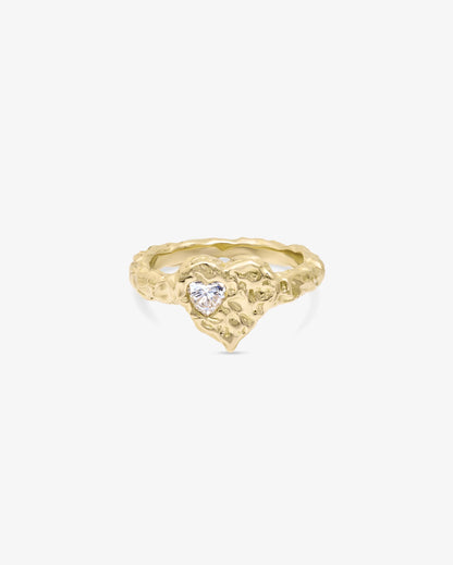 Gold ring with a heart-shaped gemstone on a white background